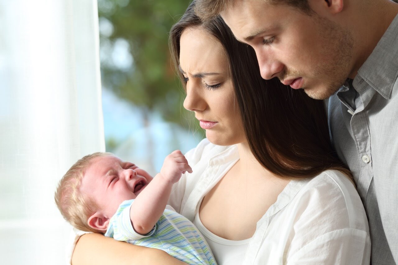 Eltern schauen auf schreiendes Baby
